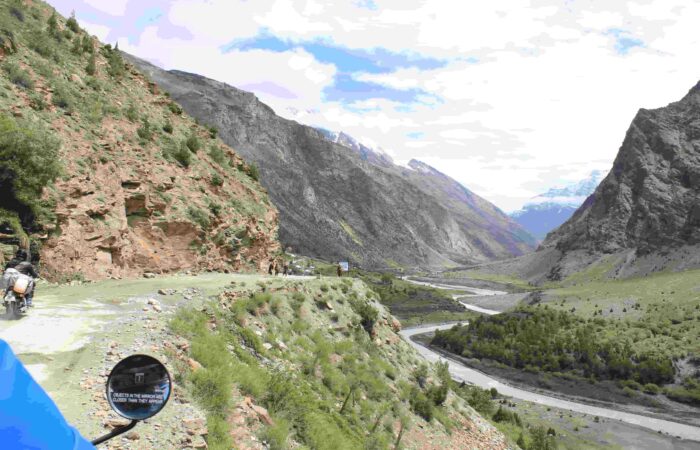 A breathtaking Himalayan valley with a river winding below the mountain roads explored on Into Wild Himalaya’s Foothills of the Himalayas Motorcycle Tour in North India.