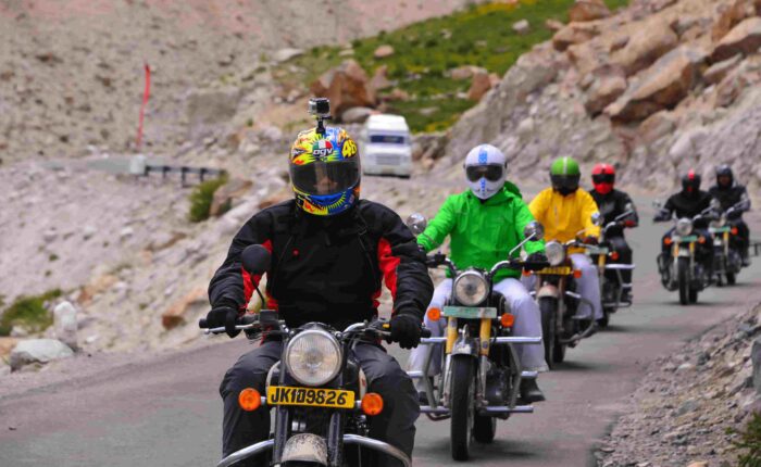 Royal Enfield riders exploring the scenic foothills of the Himalayas during Into Wild Himalaya’s guided motorcycle tour in Himachal Pradesh, India.