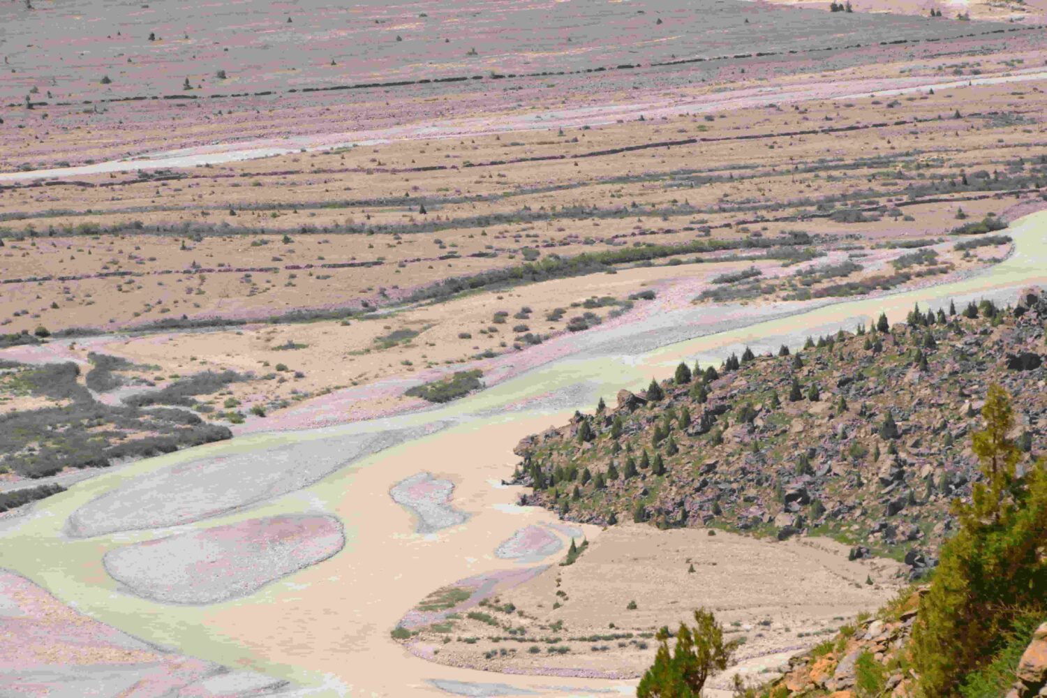 Aerial view of winding valley and turquoise river captured from Gata Loops while approaching Nakeela Pass on the Manali–Leh Highway