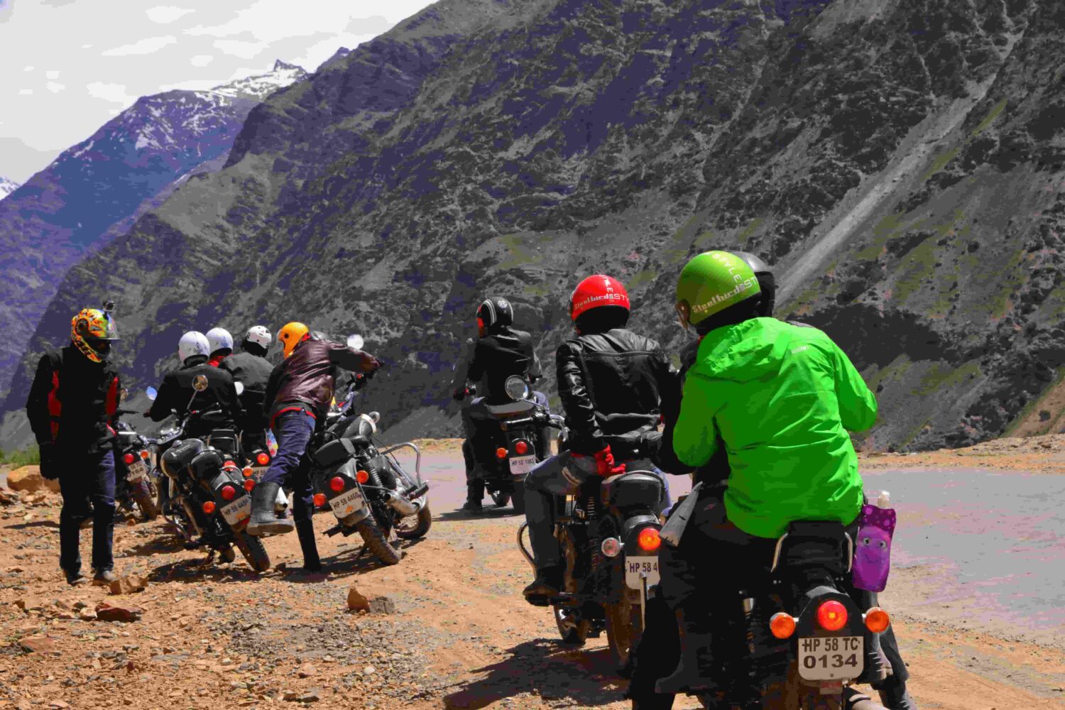 Group of bikers stopped on motorcycles discussing route on the Manali to Leh Highway, Himalayas