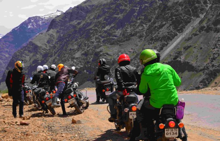Group of bikers stopped on motorcycles discussing route on the Manali to Leh Highway, Himalayas