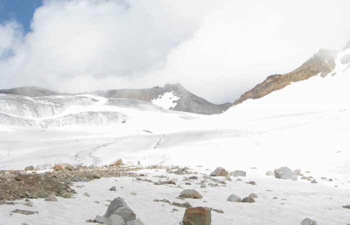 Glacier-covered high mountain pass at Pin Parvati Pass Trek in the Himalayas with snow and rugged terrain.