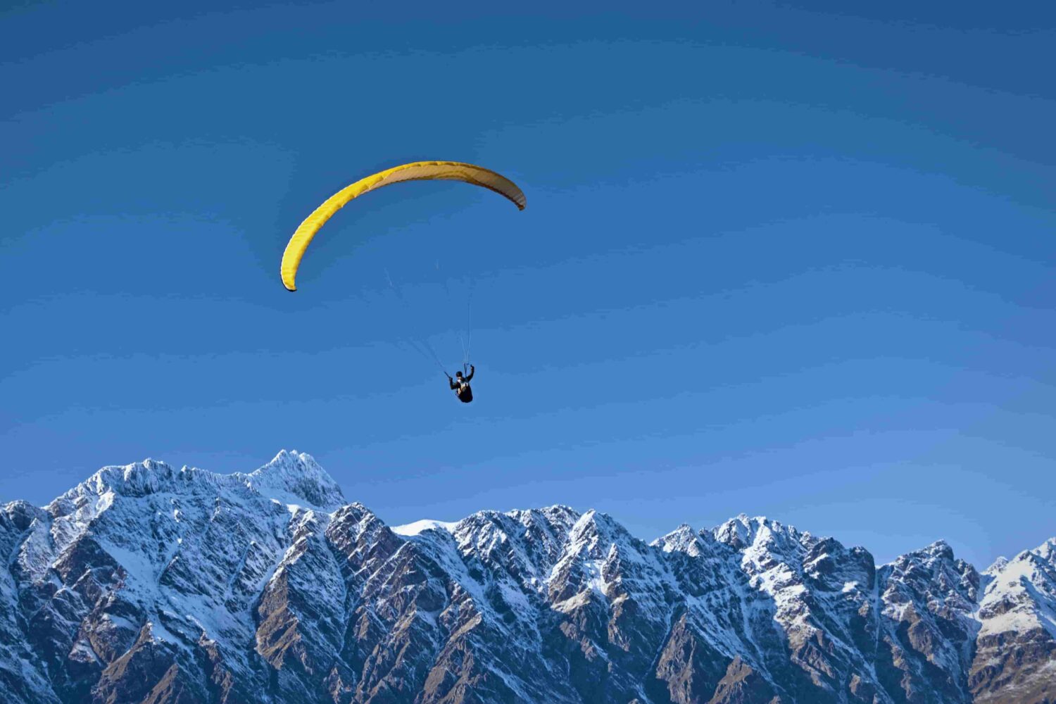 Beginner paraglider taking off from the training hill during basic paragliding course in Manali, Himachal Pradesh.