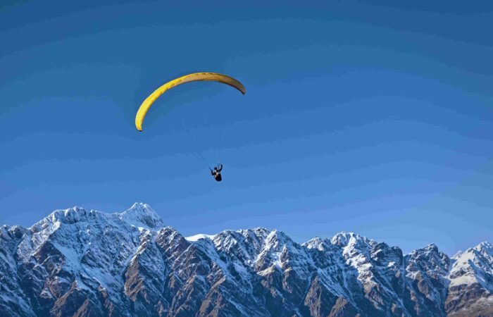 Beginner paraglider taking off from the training hill during basic paragliding course in Manali, Himachal Pradesh.
