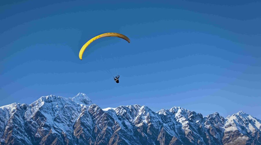 Beginner paraglider taking off from the training hill during basic paragliding course in Manali, Himachal Pradesh.