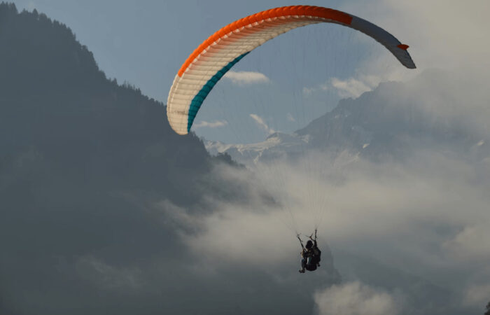 Student paraglider flying solo above Beas Valley during the beginners paragliding training course in Manali, Himachal Pradesh.