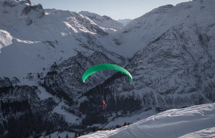 Group of beginner paragliders flying above the training site during the paragliding course in Manali, Himachal Pradesh.