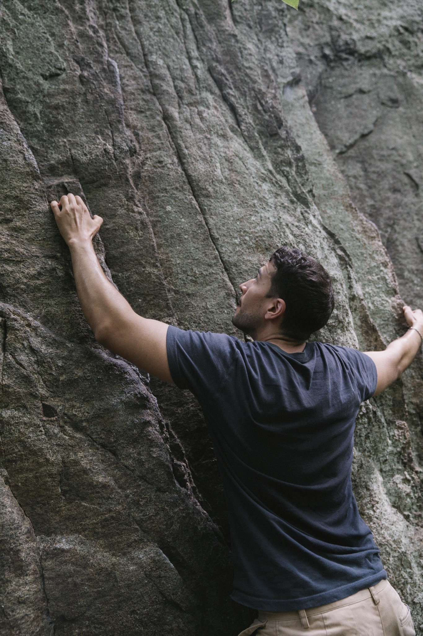 Beginner practising a low bouldering problem with a crash pad