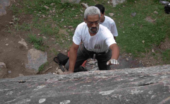 Climber practicing lead climbing on natural granite wall at Aleo, Manali with Into Wild Himalaya instructors.
