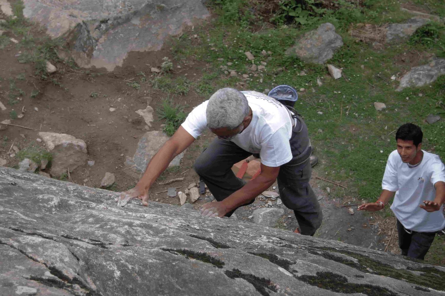Instructor guiding a climber on natural granite route during lead climbing training in Aleo, Manali with Into Wild Himalaya.