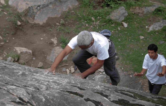 Instructor guiding a climber on natural granite route during lead climbing training in Aleo, Manali with Into Wild Himalaya.