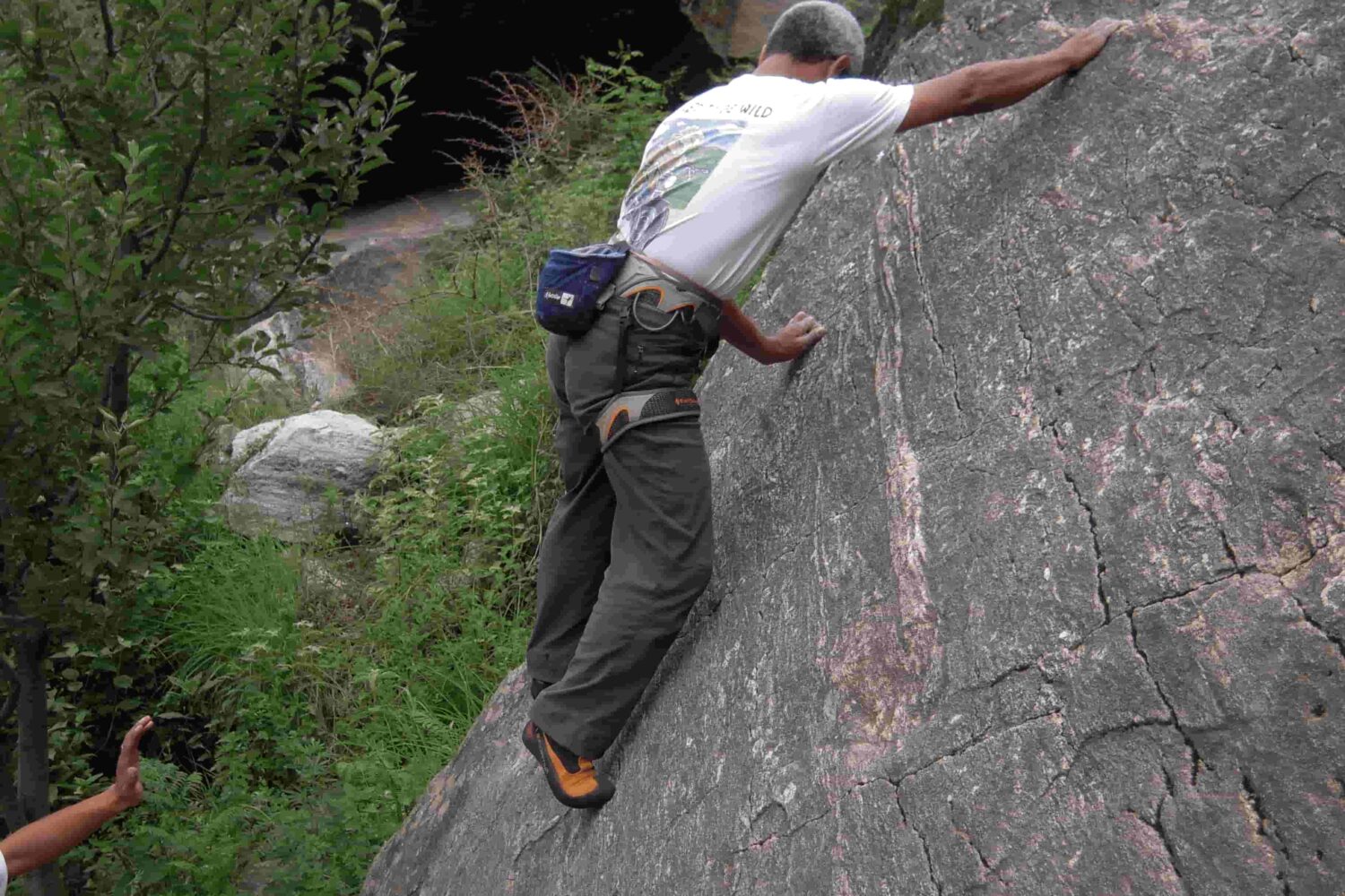 Climber balancing on granite rock face during outdoor rock climbing session in Aleo, Manali with Into Wild Himalaya.