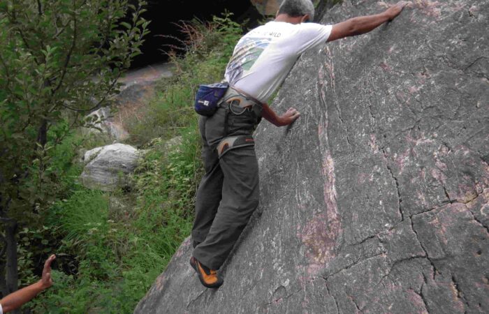 Climber balancing on granite rock face during outdoor rock climbing session in Aleo, Manali with Into Wild Himalaya.