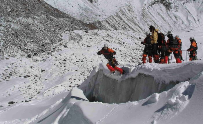 Beginner mountaineering students practicing crevasse crossing and snow techniques during the Private Basic Mountaineering Course in Manali India, guided by certified instructors on Himalayan glacier terrain.