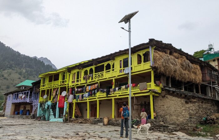 A traditional Kathkuni-style house in Solang Village near Manali with hay stored for cattle, seen along the Patalsu Peak Day Hike trail.