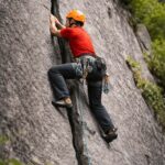 Rock climber practicing crack climbing technique in Sethan near Manali, Indian Himalayas with certified guides