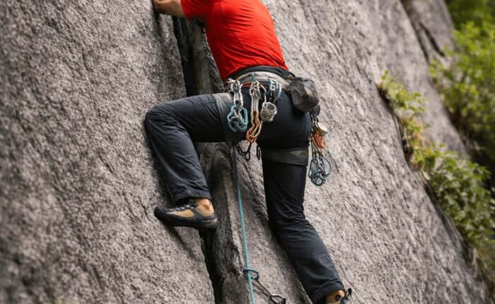 Rock climber practicing crack climbing technique in Sethan near Manali, Indian Himalayas with certified guides