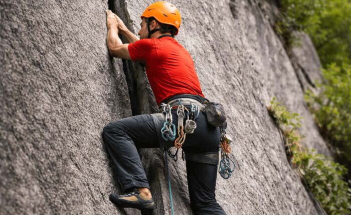Rock climber practicing crack climbing technique in Sethan near Manali, Indian Himalayas with certified guides