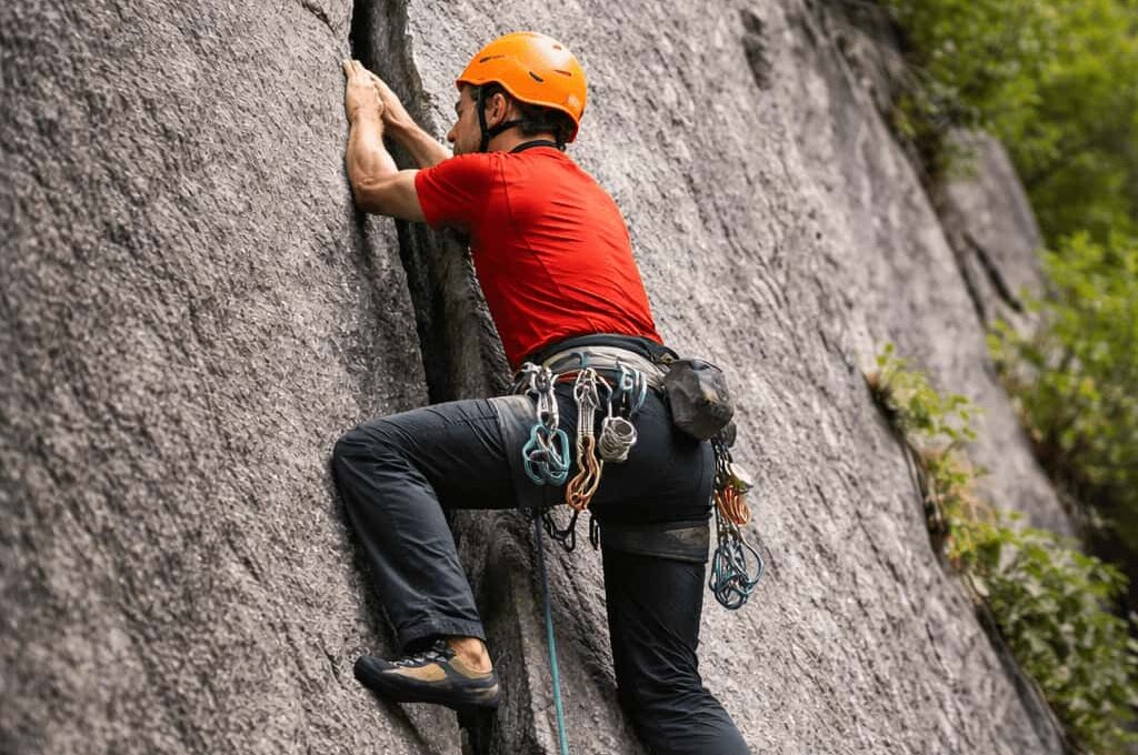 Rock climber practicing crack climbing technique in Sethan near Manali, Indian Himalayas with certified guides