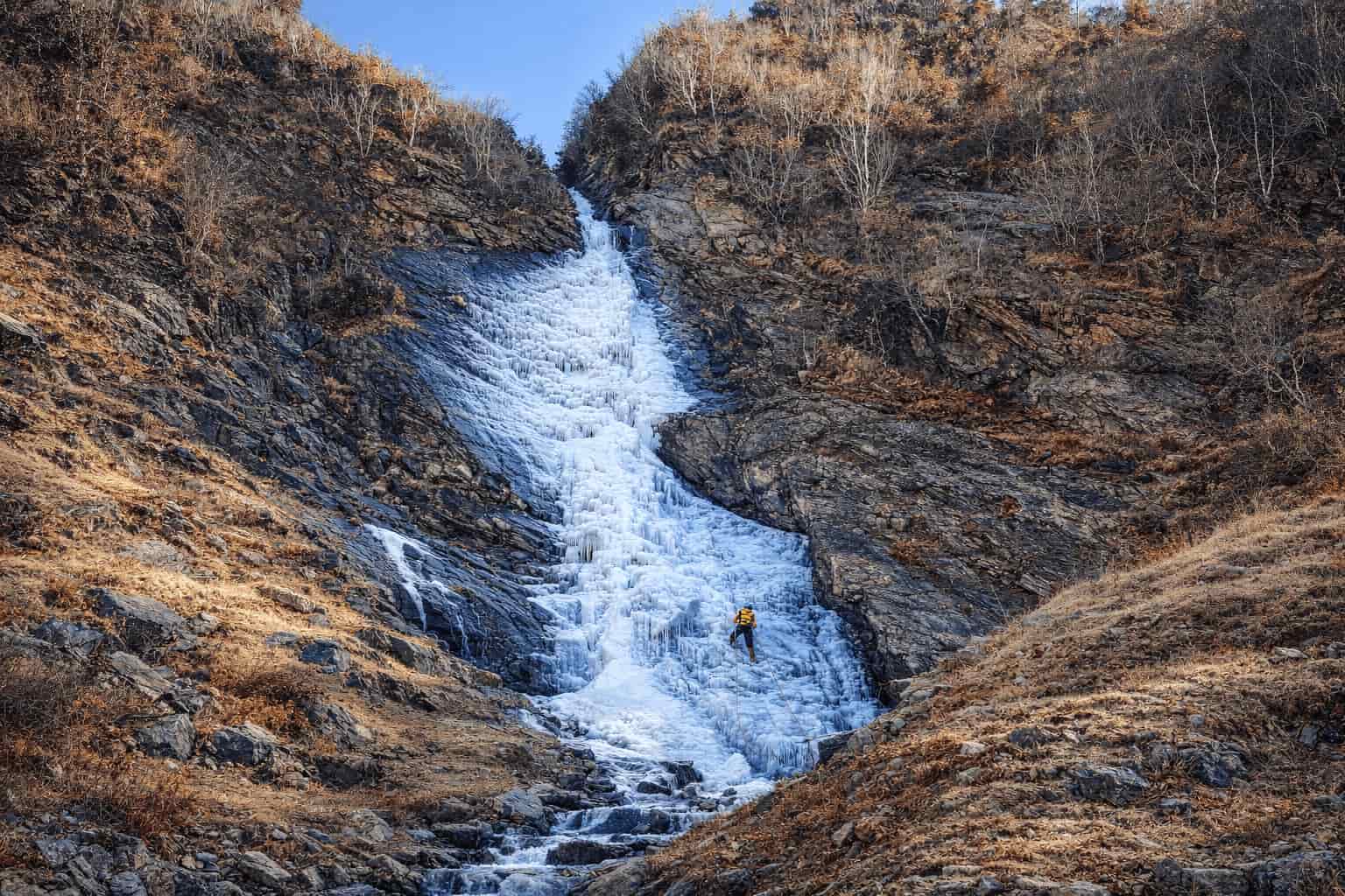 A frozen waterfall of water ice on a rock face near Manali in winter